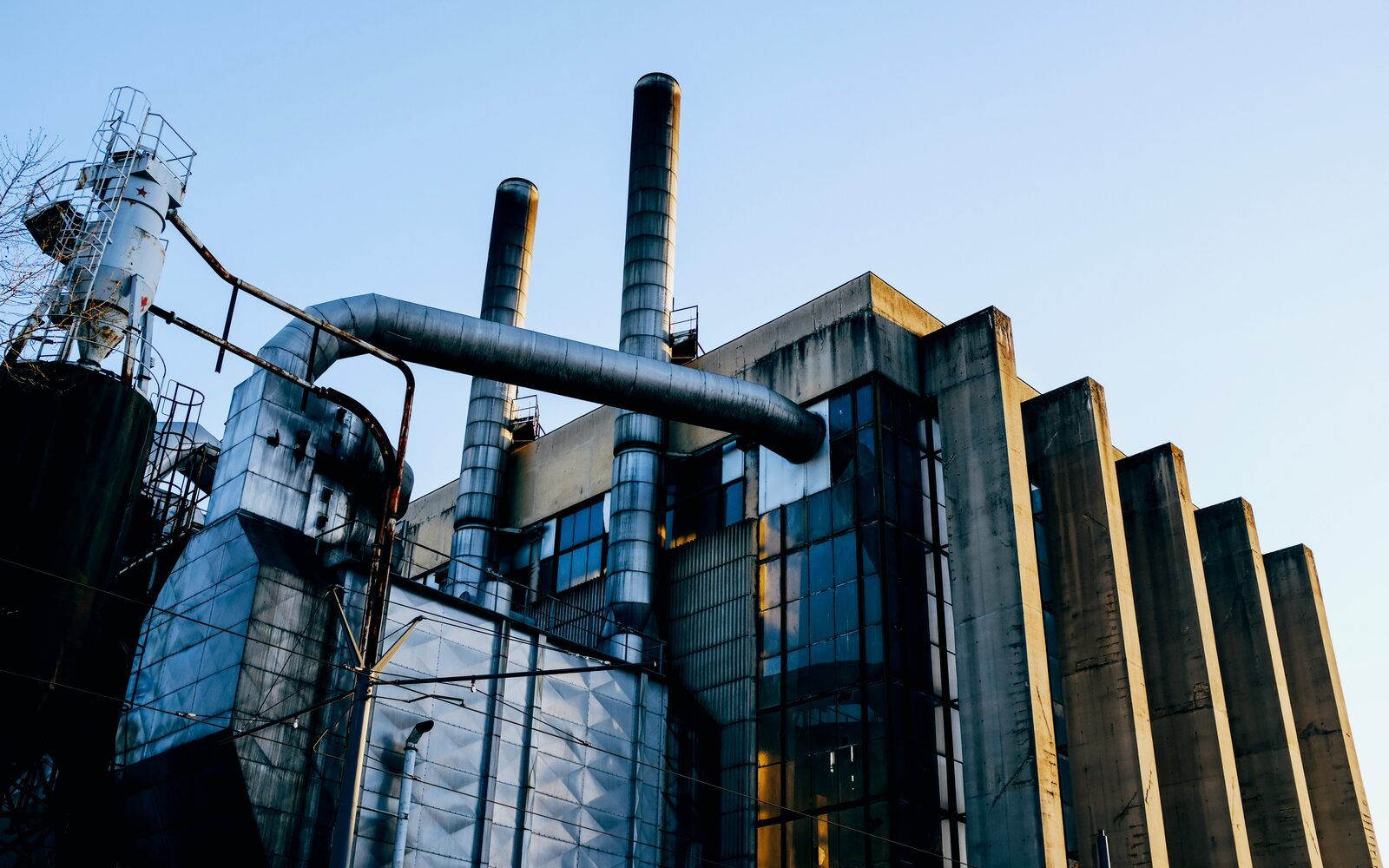 Industrial manufacturing plant with stacks and process piping