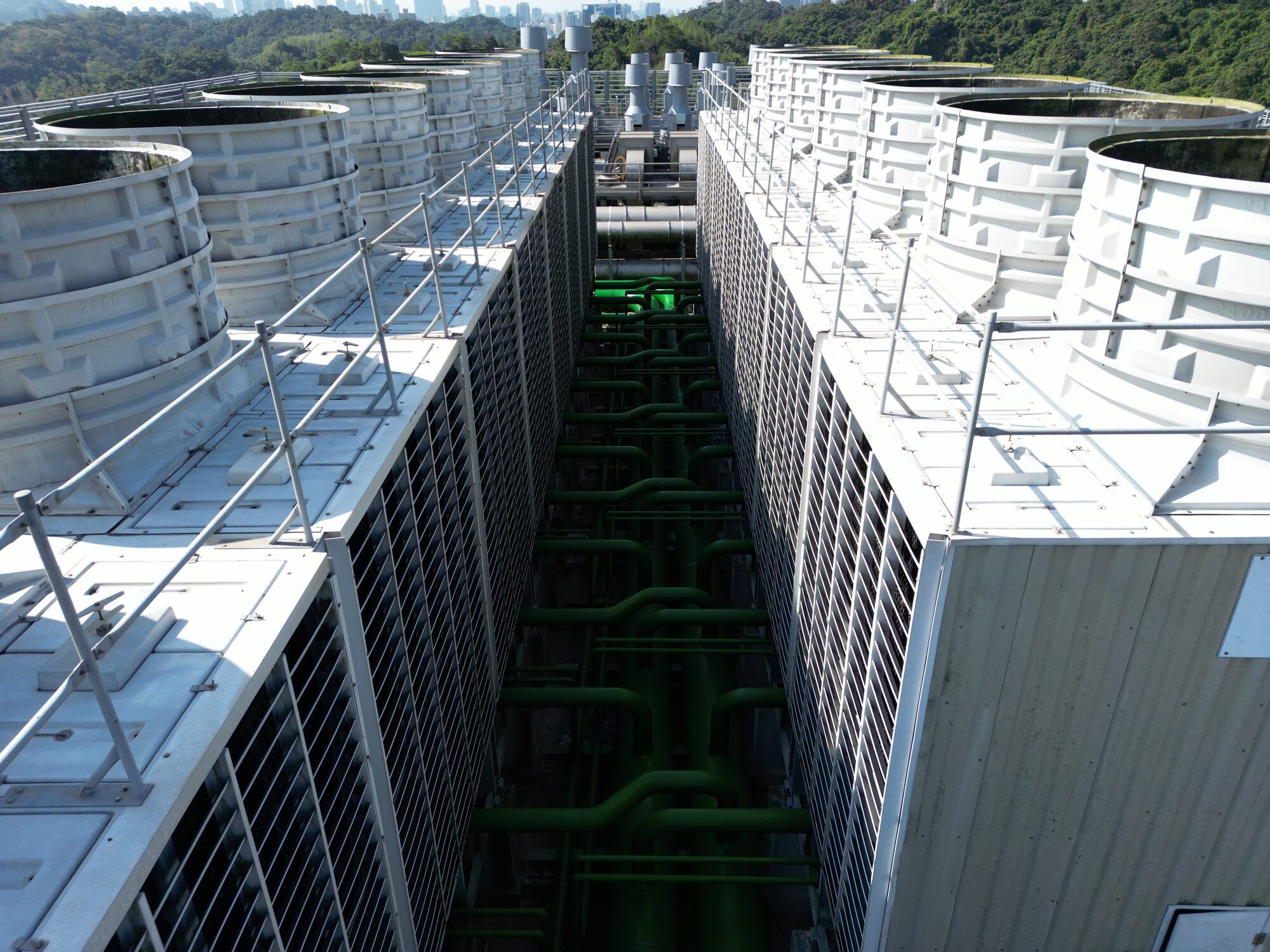 Rows of industrial cooling towers on a facility rooftop