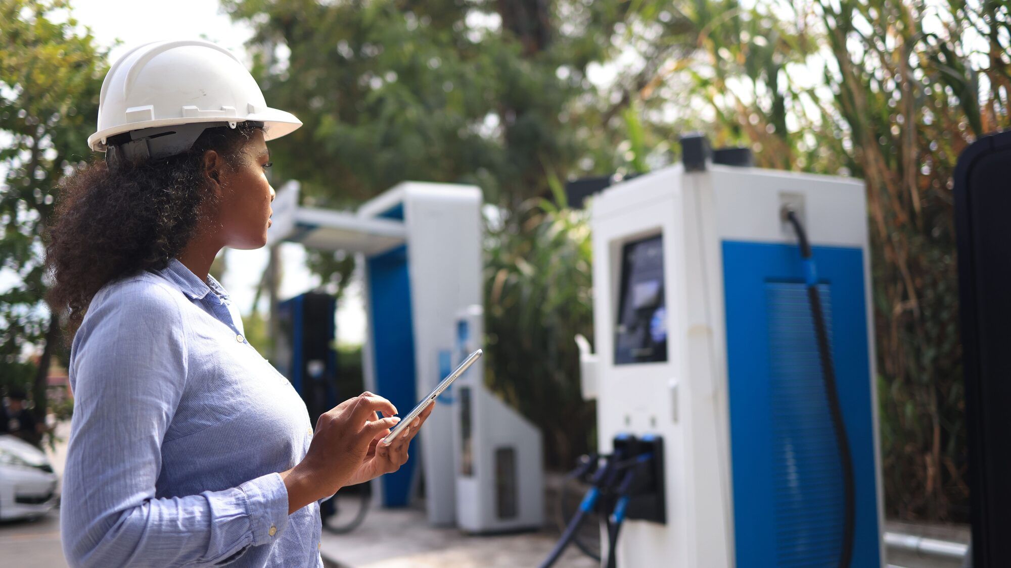 A LightChange field engineer inspecting equipment with a tablet